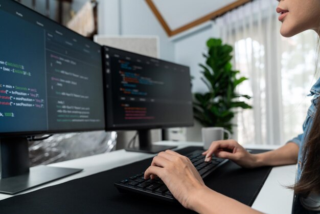 Joven asiático en TI creando con el teclado de información en línea en PC Stratagem