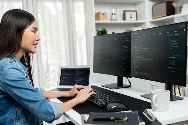 Joven asiático en TI creando con el teclado de información en línea en PC Stratagem
