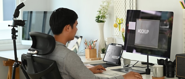 Joven asiático trabajando desde casa en una computadora