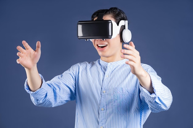 Joven asiático usando gafas VR en segundo plano