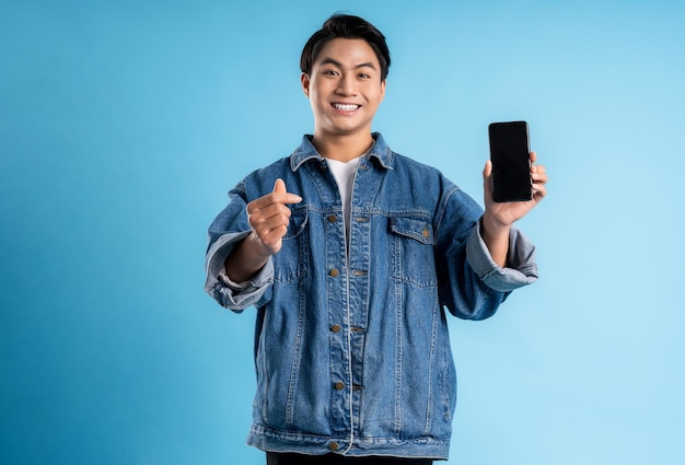 Un joven asiático usando un teléfono con un fondo azul