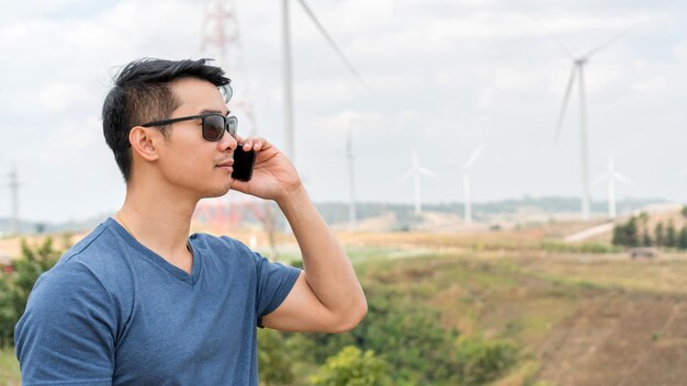 Joven asiático usando un teléfono en una montaña