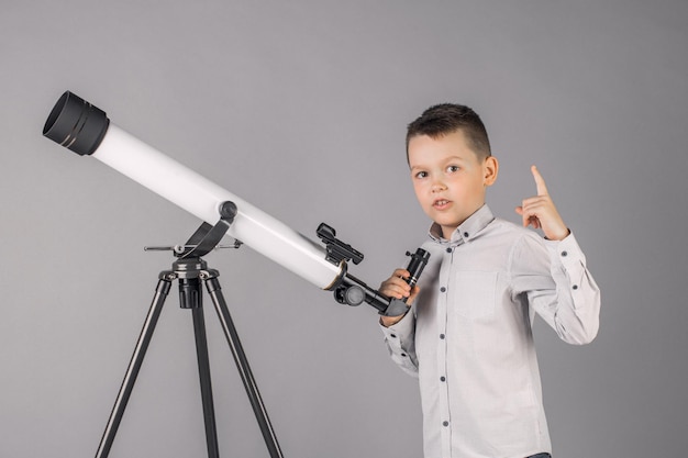 El joven astrónomo mira a través de un telescopio y escribe en la tablilla.