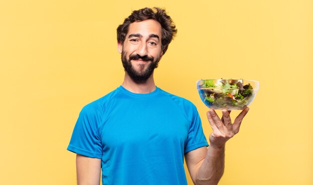 Joven atleta barbudo loco feliz expresión y concepto de dieta