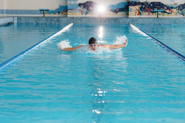 Un joven atleta entrena y se prepara para las competiciones de natación en la piscina. Estilo de vida saludable.