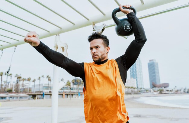 Joven atleta entrenando por la mañana en la playa en el gimnasio