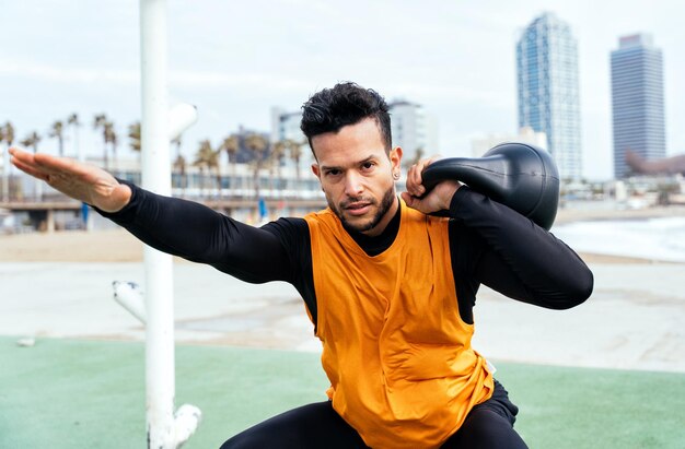 Joven atleta entrenando por la mañana en la playa en el gimnasio