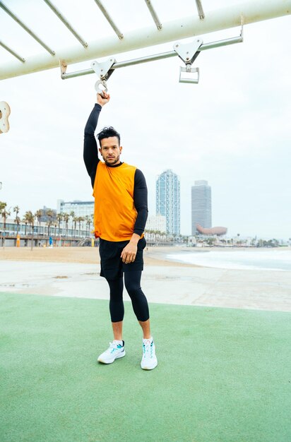 Joven atleta entrenando por la mañana en la playa en el gimnasio