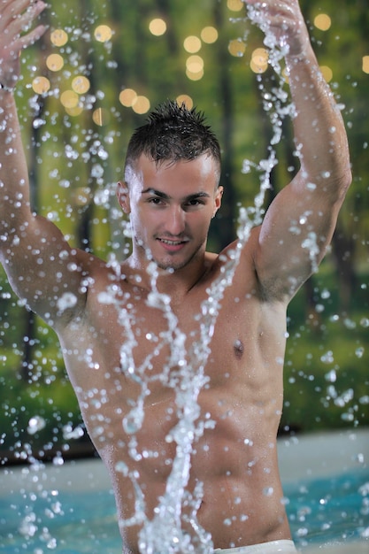Joven atleta modelo de hombre macho guapo saludable en la piscina cubierta del hotel