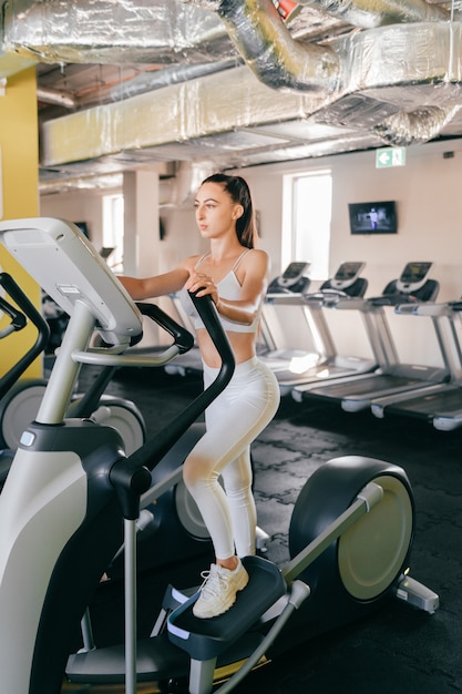 Joven atleta mujer cardio entrenamiento en gimnasio