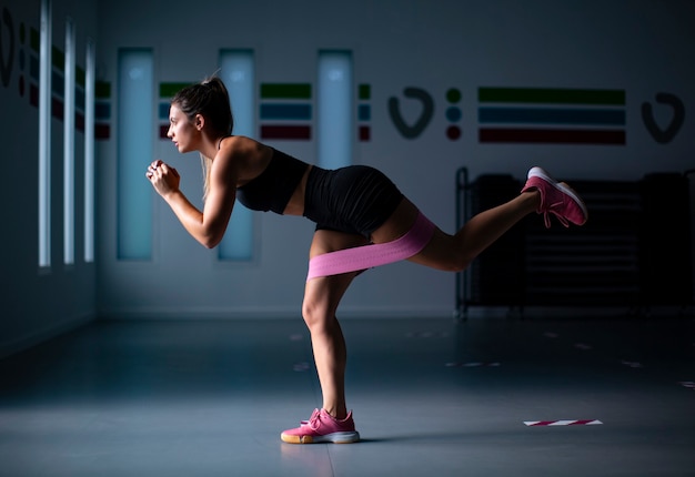 Joven atleta trabajando en el gimnasio con banda elástica