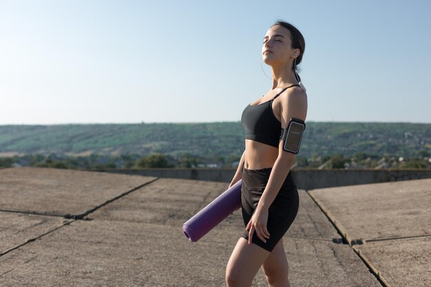 Una joven atlética delgada con ropa deportiva con estampados de piel de serpiente realiza una serie de ejercicios