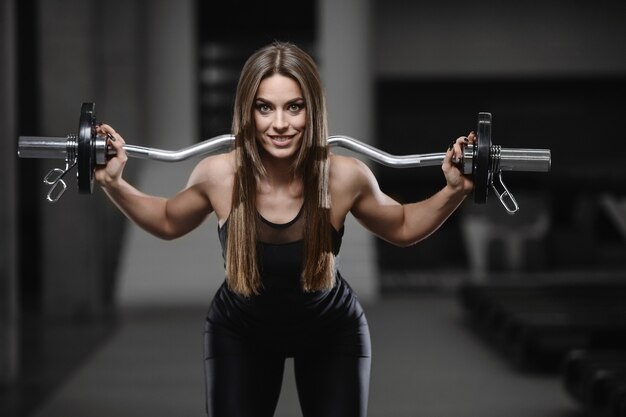 Joven atlética fuerte trabajando en el gimnasio