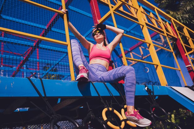 Foto joven atlética haciendo ejercicio y escalando en el campo de entrenamiento