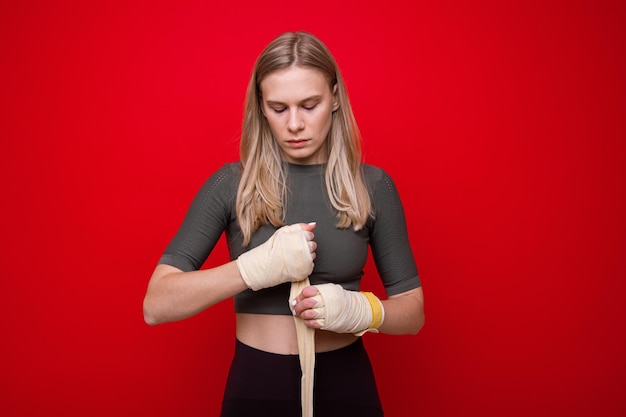 Joven atlética se venda las manos antes del entrenamiento de boxeo