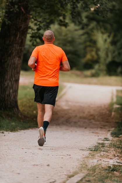 Joven atlético corriendo en la naturaleza Estilo de vida saludable