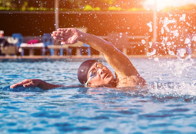 Joven atlético nadando en la piscina