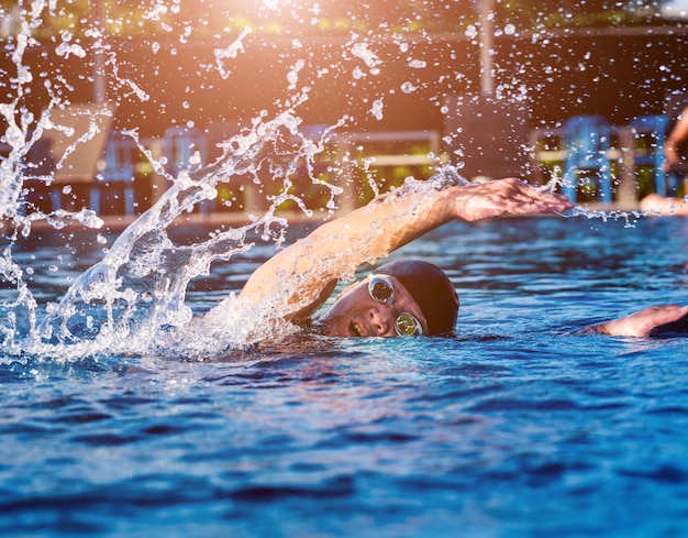 Joven atlético nadando en la piscina