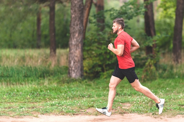 Joven atlético trotando en el parque