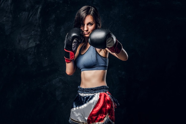 Una joven y atractiva boxeadora con cabello largo y guantes de boxeo está lista para pelear.