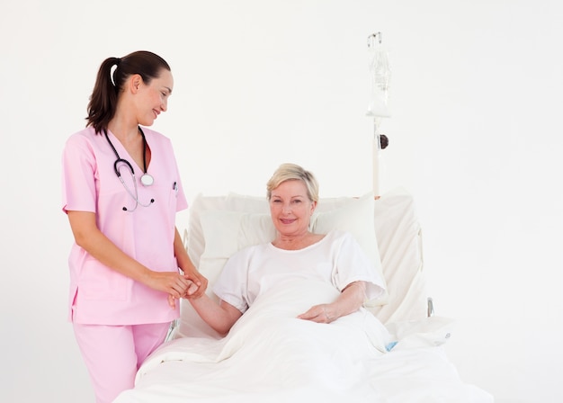 Joven atractiva enfermera con un anciano agradable paciente