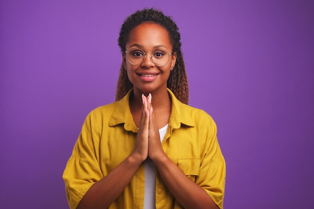 Joven atractiva mujer afroamericana hace gesto de orar
