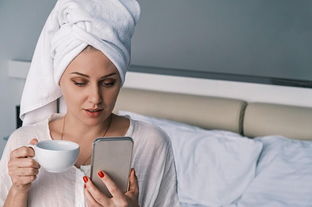 Joven atractiva mujer milenaria usa su teléfono leyendo las noticias desplazando un feed de redes sociales sitt