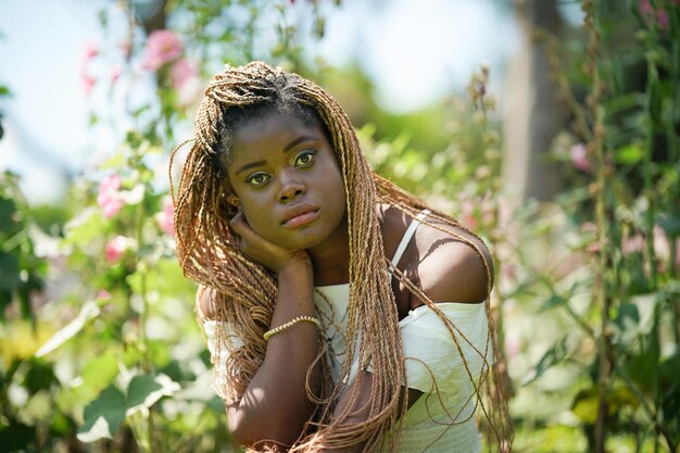 Joven atractiva mujer de piel negra peinado afro en el fondo de la naturaleza