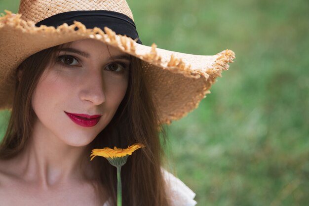 Joven atractiva tiene una flor silvestre de verano.