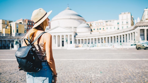 Joven atractiva turista sonriente explorando una nueva ciudad en verano