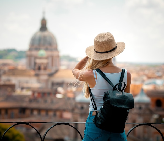 Joven atractiva turista sonriente con sombrero explorando la nueva ciudad de Europa en las vacaciones de verano