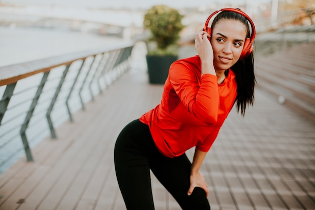 Foto joven atractivo corredor femenino tomando descanso después de correr al aire libre