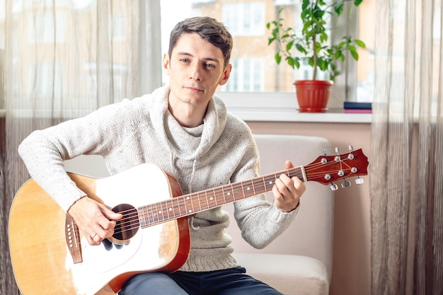 Joven atractivo tocando la guitarra