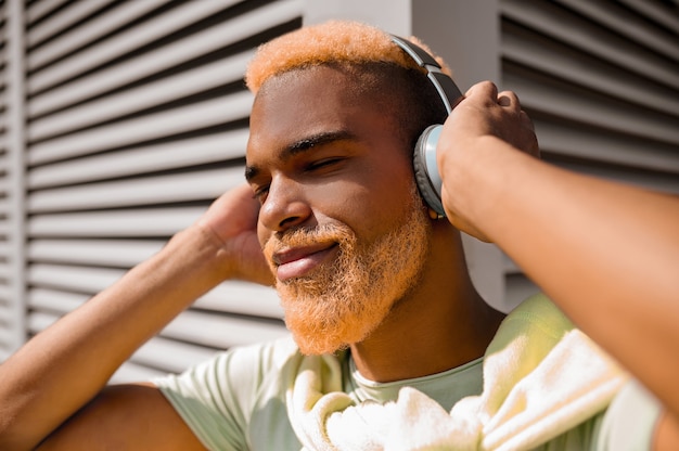 Un joven en auriculares escuchando música y mirando disfrutado