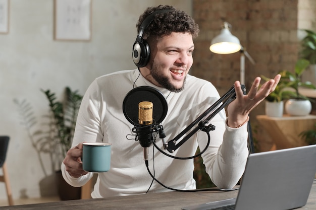 Joven en auriculares con micrófono y grabación de podcast o entrevista para radio