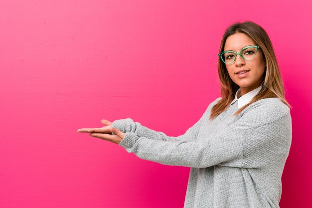 Foto joven auténtica mujer carismática de personas reales contra una pared con un espacio de copia en una palma.