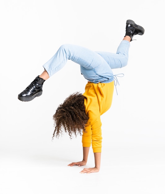 Joven bailando sobre pared blanca aislada