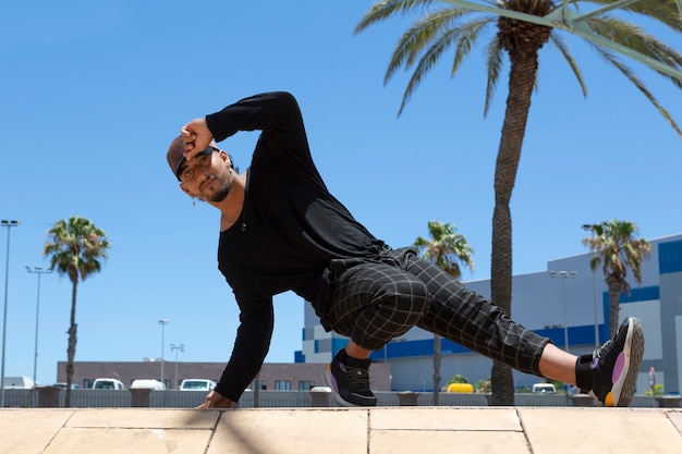 Joven bailarín acrobático urbano latino en la calle haciendo una actuación.