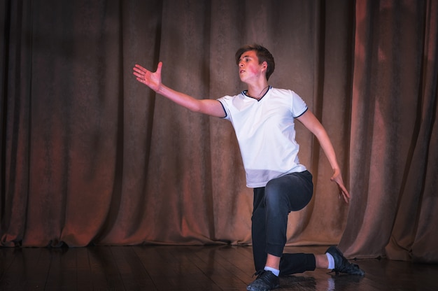 Un joven bailarín ensayando en el escenario, los elementos de la danza. Las emociones en la coreografía