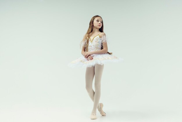 Foto una joven bailarina adolescente muestra pasos de ballet en un estudio fotográfico