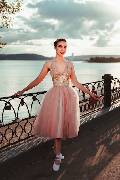 Foto una joven bailarina elegante con un vestido rosa con una falda de organza completa, una bailarina posa cerca de un ...