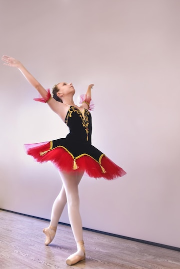 Una joven bailarina se elegantemente con zapatos de punta en los dedos de los pies en el estudioestudiante de ballet practicando danza clásica en el estudio antes de la actuación