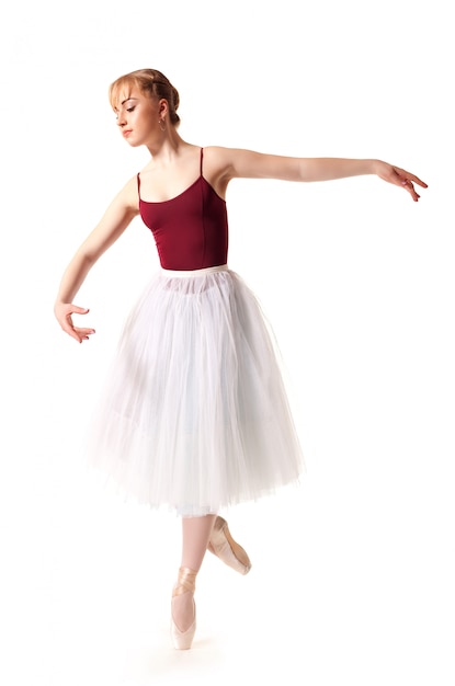 Joven bailarina hermosa en tutú blanco y zapatos de punta haciendo pose de baile