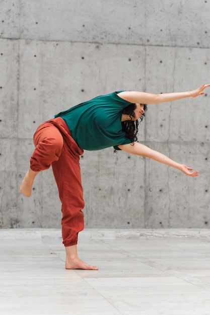 Joven bailarina realizando una danza moderna en el escenario