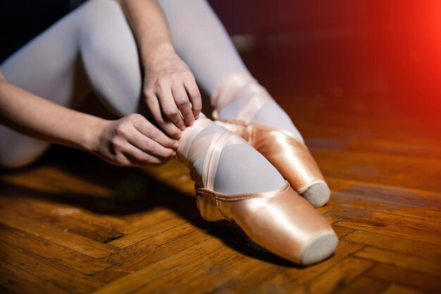 Joven bailarina sentada piernas y zapatos dorados Concepto de arte clásico Preparándose para el primer plano de baile