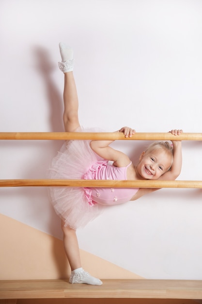 Una joven bailarina con un vestido rosa participa en un estudio de ballet