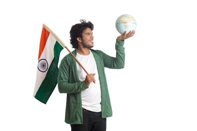 Joven con bandera india o tricolor con globo terráqueo sobre fondo blanco.