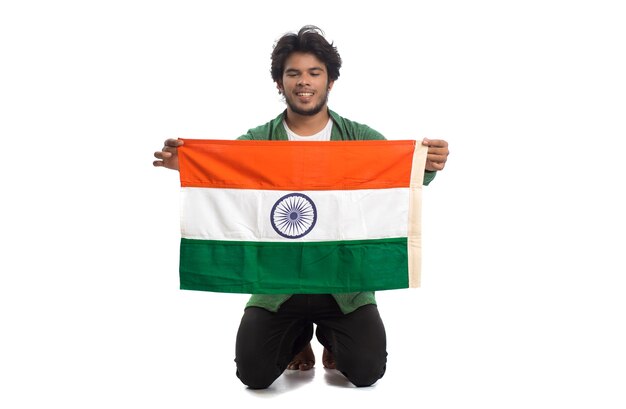 Joven con bandera india o tricolor sobre fondo blanco.