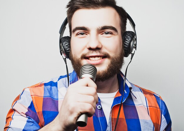 joven con barba con una camisa con un micrófono