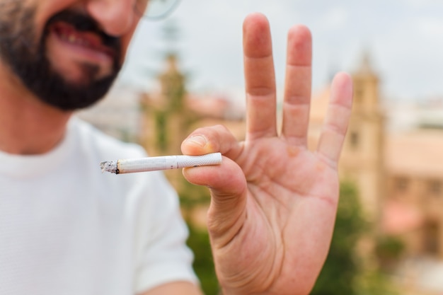 Joven barbudo fumando un cigarrillo